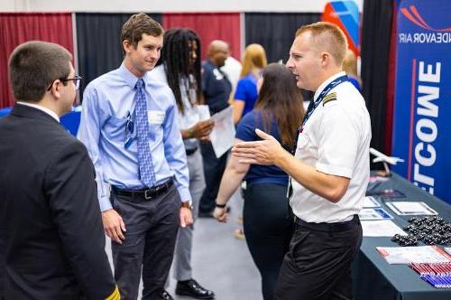 Students speak with an airline representative at the aeronautics career fair