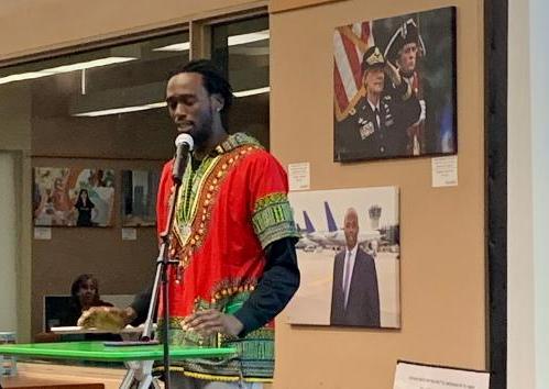 Male speaker at past event with images behind him.